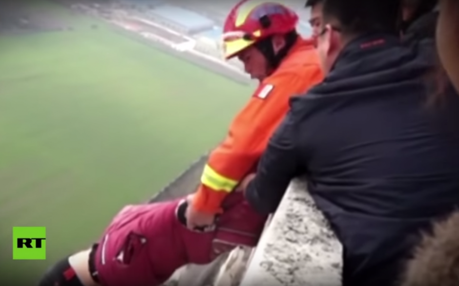 Momento en el que los rescatistas sostienen al hombre que pretend&iacute;a lanzarse del edificio. (Imagen: captura de pantalla)