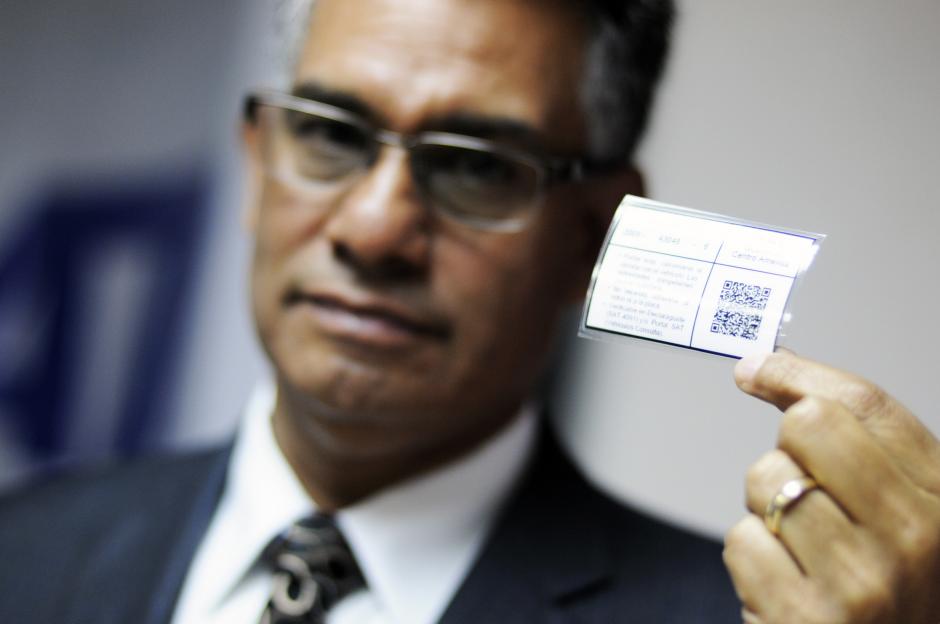 Carlos Mu&ntilde;oz, jefe de la SAT, present&oacute; este jueves la nueva calcoman&iacute;a electr&oacute;nica (que sostiene en su mano) la cual podr&aacute; ser generada desde cualquier computadora y no deber&aacute; pegarse al veh&iacute;culo. (Foto: Esteban Biba/Soy502)