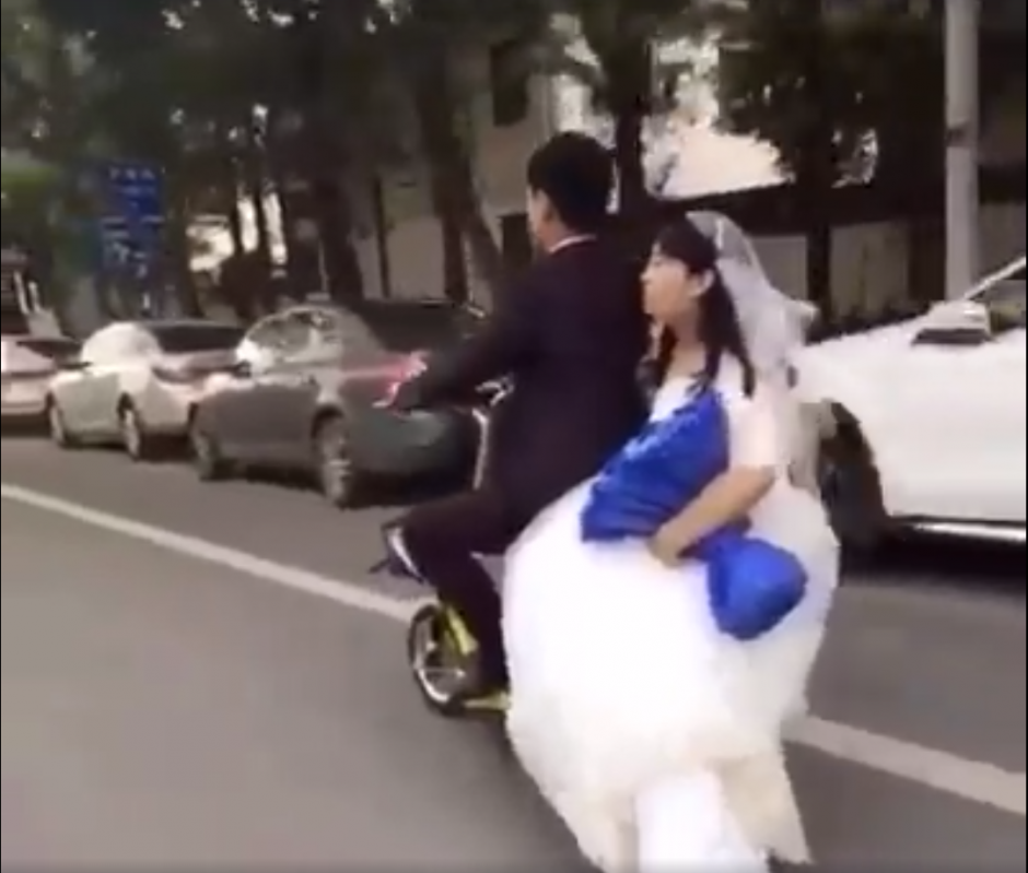 La pareja de reci&eacute;n casados circula por las calles de China. (Captura de pantalla: People's Daily, China/Facebook)