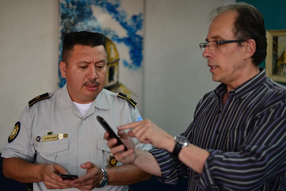 El subcomisario Elvin Juárez es captado junto a Carlos Proesamer, quien es uno de los voluntarios que participan en las redes de WhatsApp que apoyan a la PNC con información que luego es verificada por agentes. (Foto: Wilder López/Soy502)