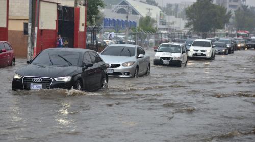 Dos carros son arrastrados por una correntada causada por la lluvia