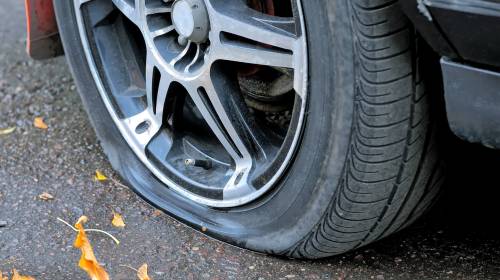 El carro que avanza a toda velocidad con dos llantas destruidas