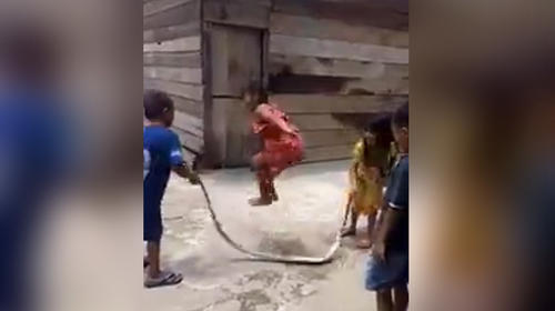 Ni&ntilde;os saltan la cuerda con una serpiente muerta