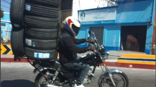 Captan arriesgada maniobra de motociclista al transportar llantas