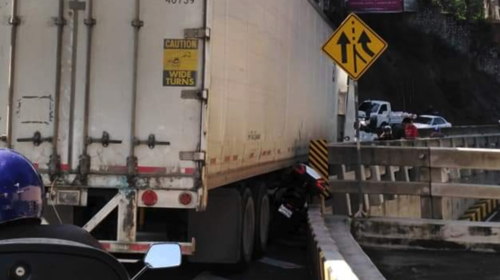 Motorista intenta rebasar a un camión y queda atrapado 