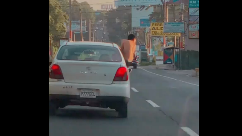 Joven arriesga su vida al exhibirse sobre un carro en movimiento