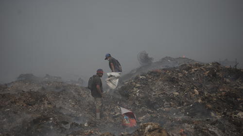 Entre el fuego, buscan basura para sobrevivir